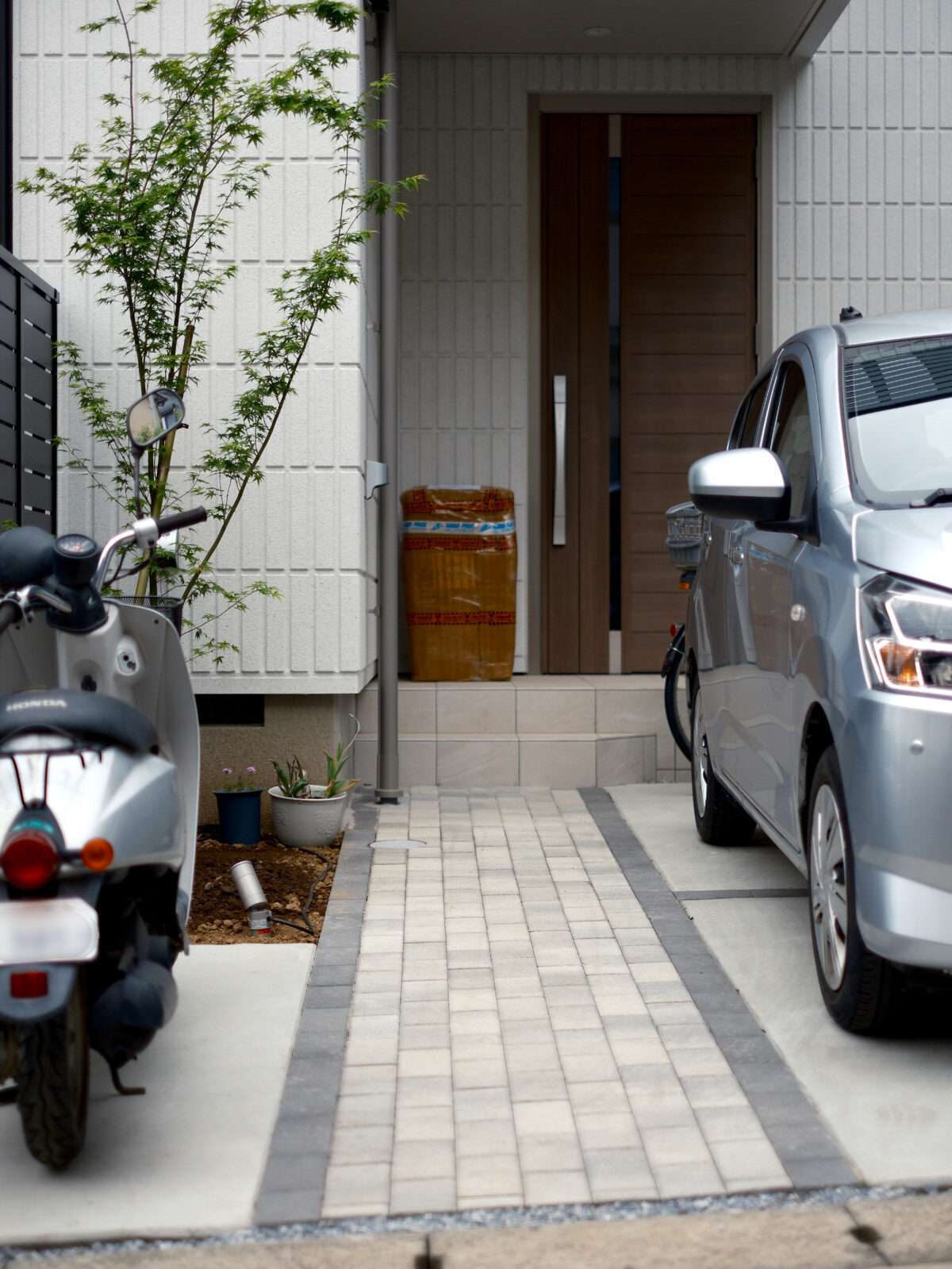 インターロッキングで仕上げたアプローチの俯瞰写真シンボルツリーが玄関への目線を和らげる