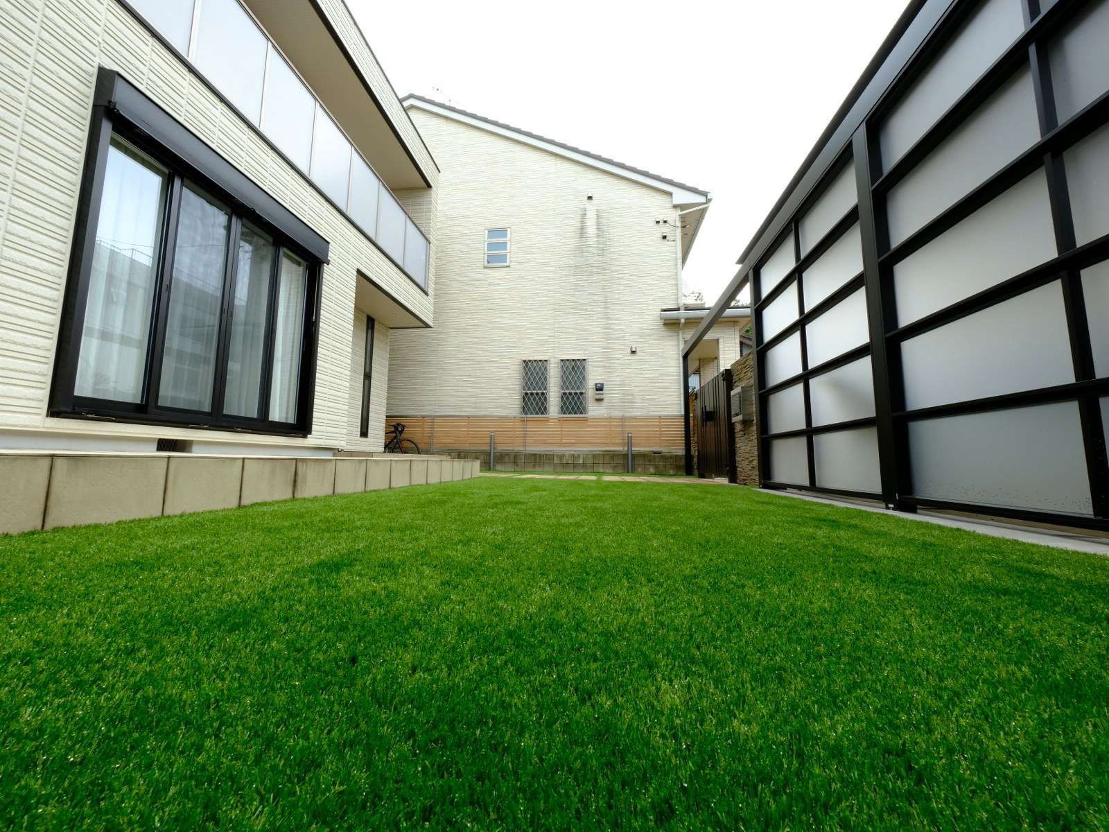 人工芝とフェンス、照明が設置されたおしゃれな庭空間