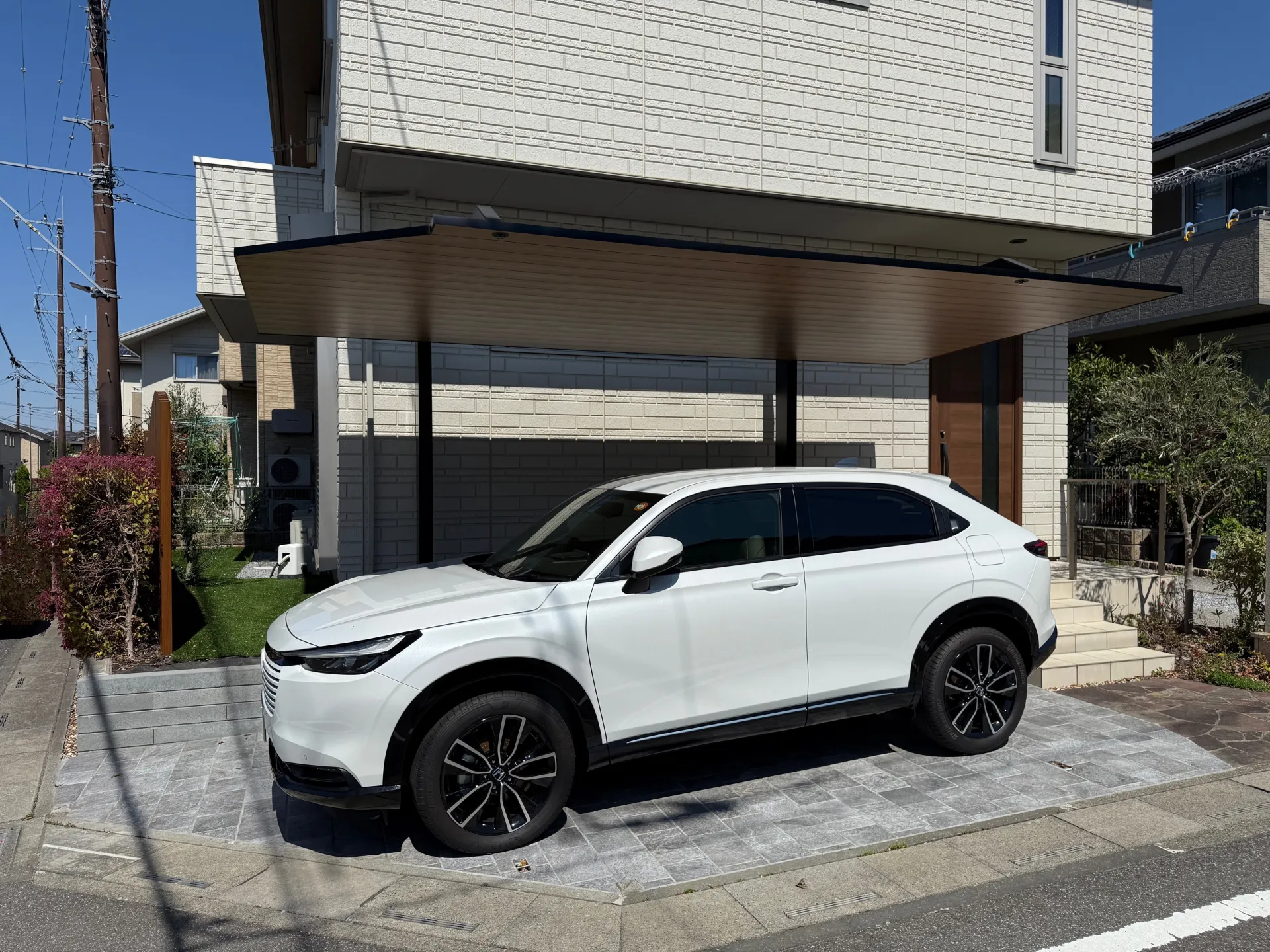 リフォーム後、植栽を撤去して広々とした駐車スペースに。アルミ屋根のカーポートがモダンな印象。