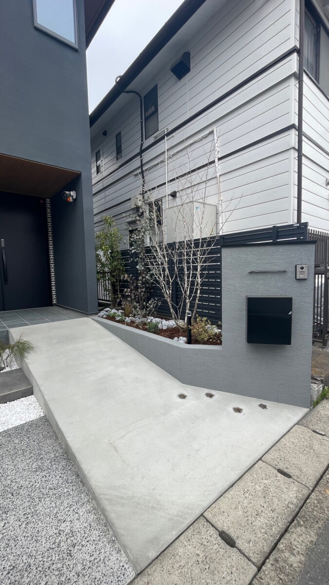 LIXILのフェンスAB(ダスクグレー)と、アオダモなどの植栽が彩る境界ライン