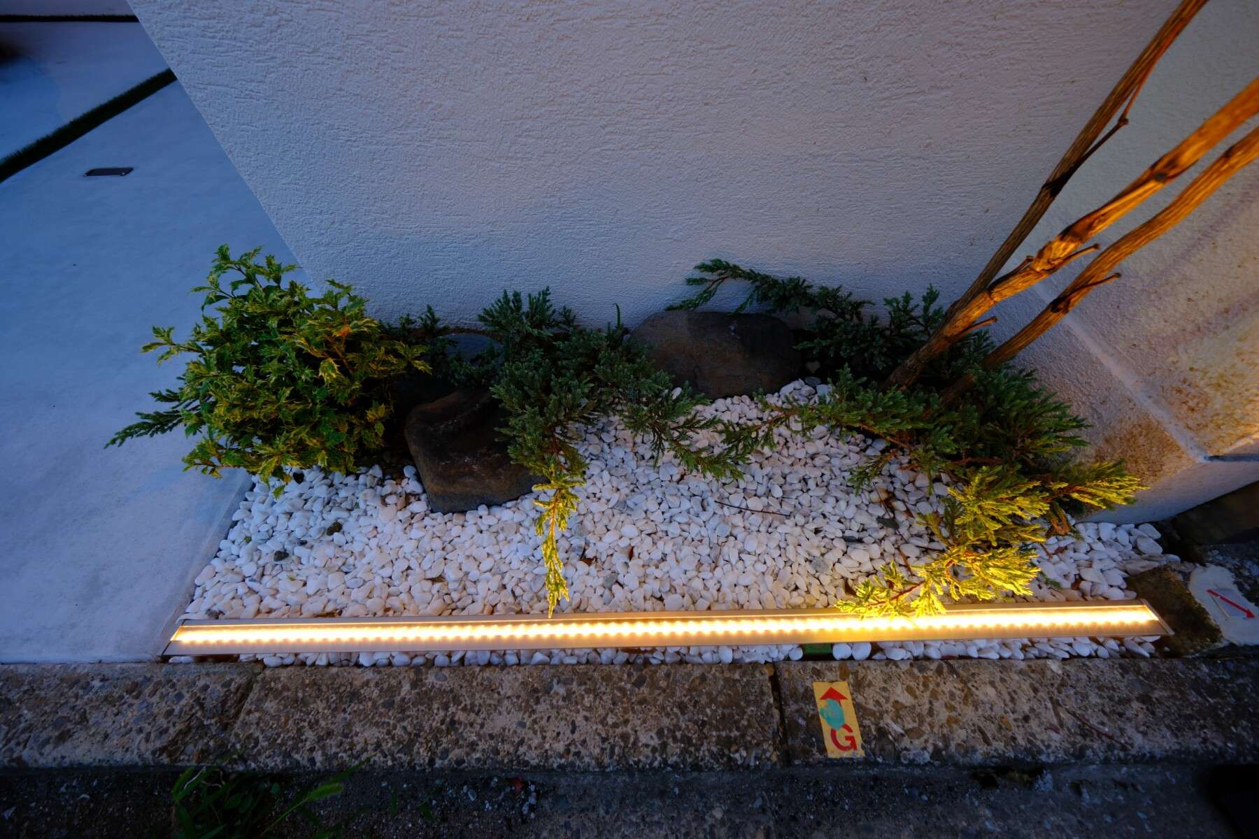 玉砂利と花壇がアクセントになったナチュラルモダンな玄関アプローチ