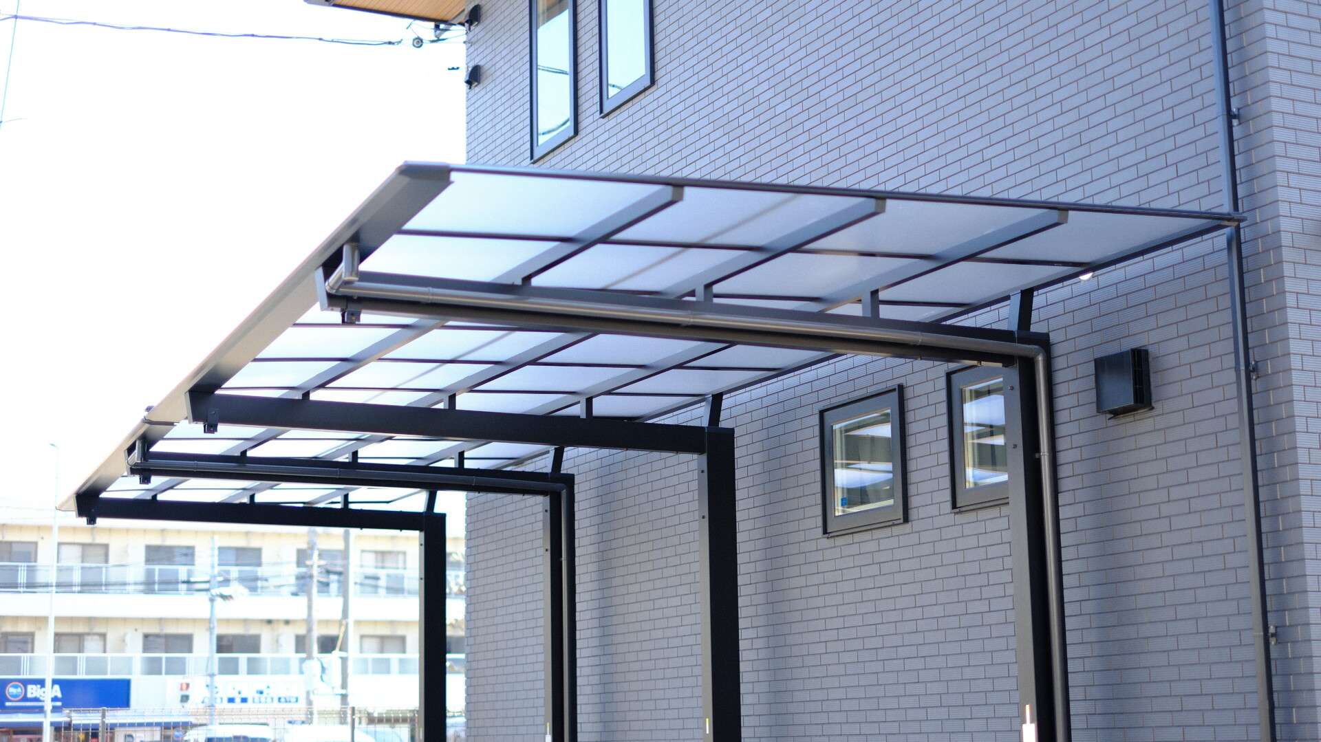 台形加工された逆勾配カーポートと1.5台分の駐車スペース。