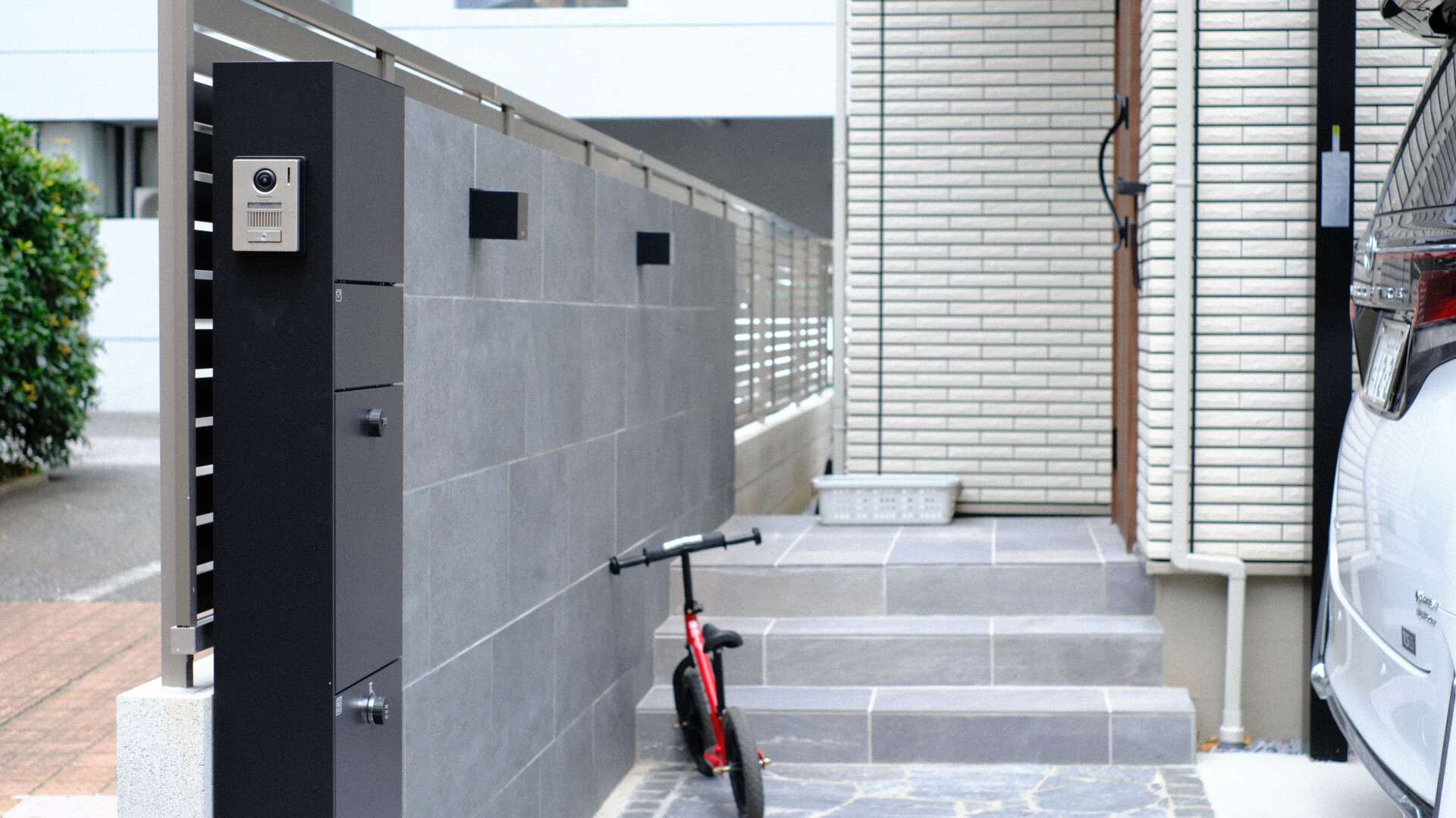 玄関ポーチへ続く自然石アプローチとグレー系の外構デザイン