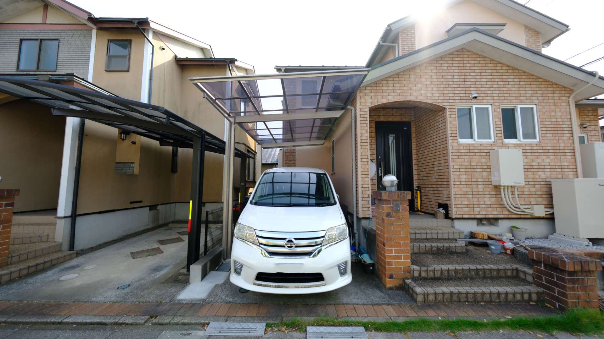 キャンピングカー対応のフーゴFタイプカーポート施工後の様子。建物との調和が美しい。