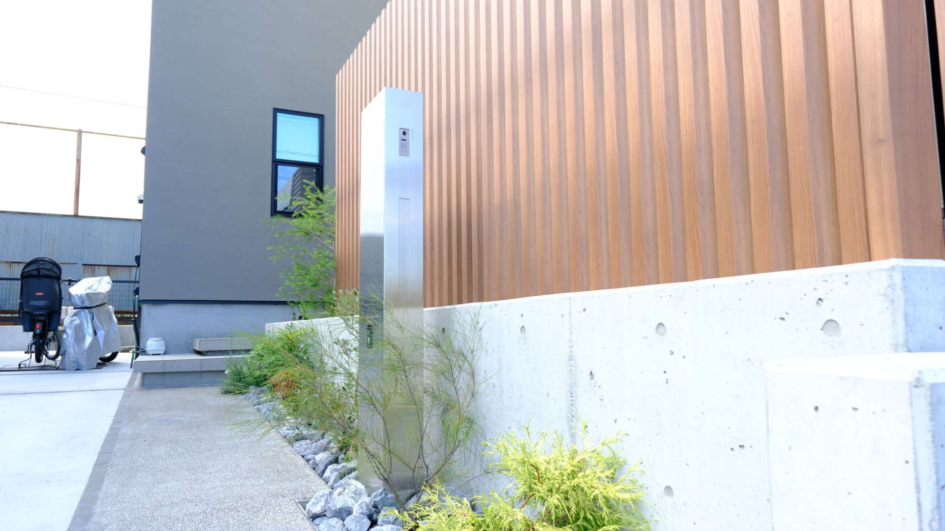 ステンレス素材の機能門柱と植栽を組み合わせたエントランスまわり