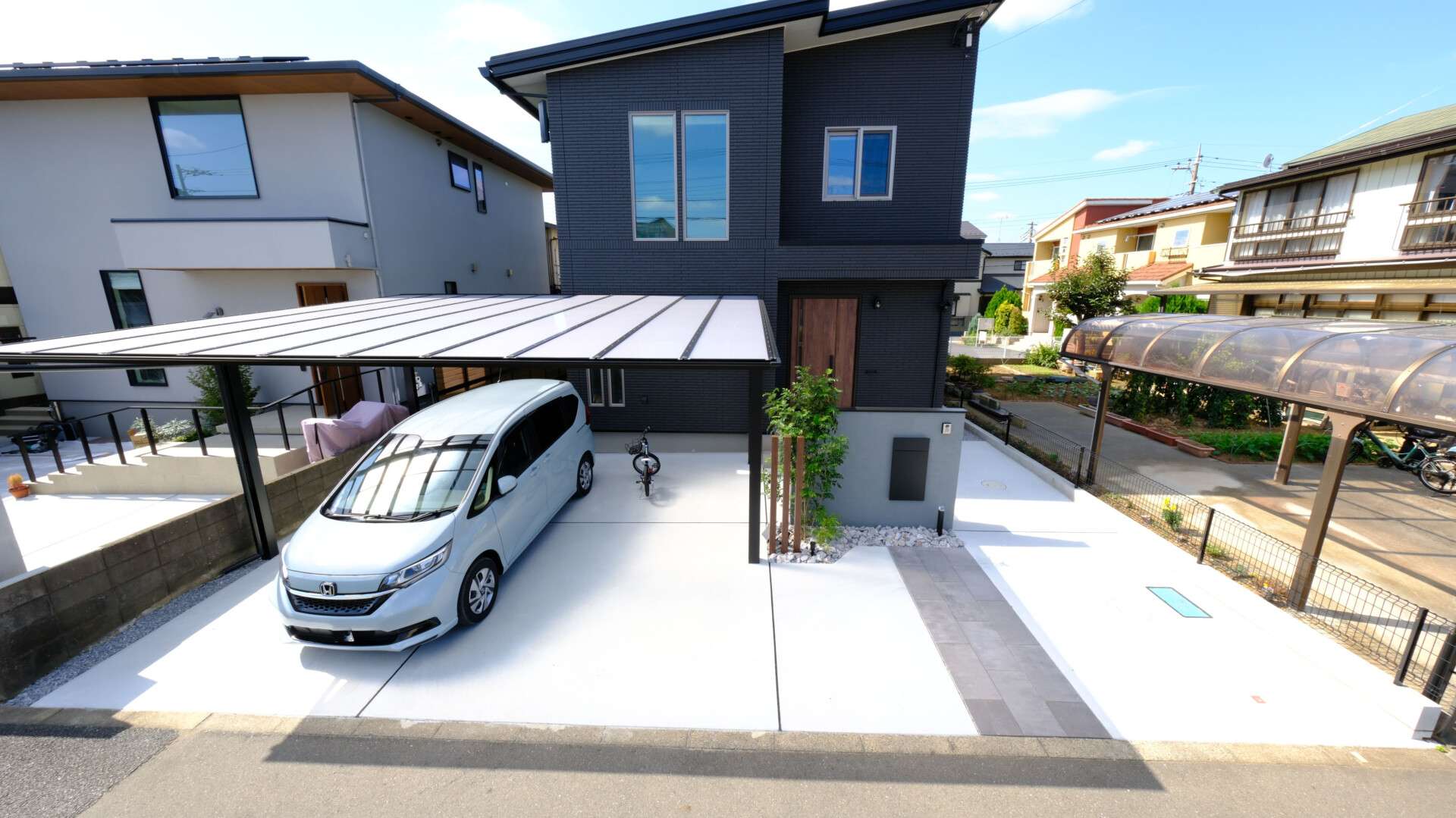 カーポートフーゴと大判タイルのアプローチがモダンな一条工務店の新築外構施工例全景