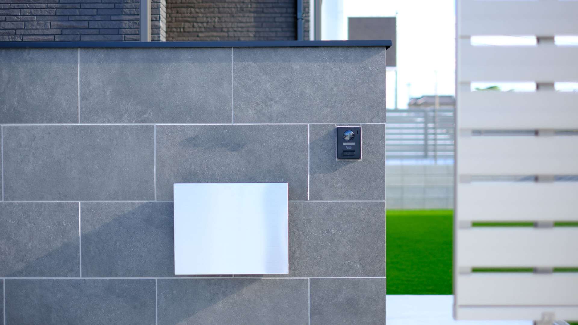 大判タイル門柱の詳細。インターホンとポストが組み込まれたデザイン。