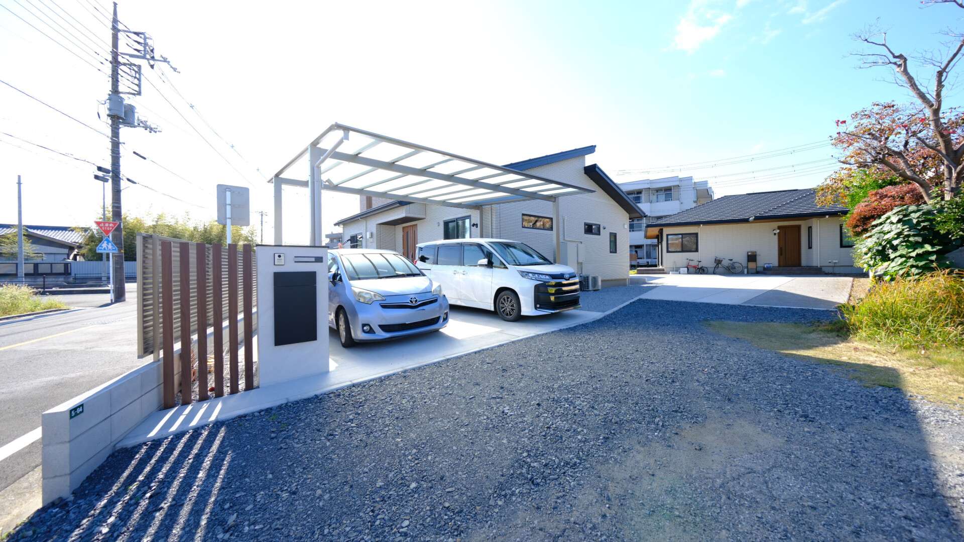 平屋の新築外構に設置された三協アルミのカーポート「スカイリード」変形地のコーナー部分に立つ枕木調のアクセント角柱