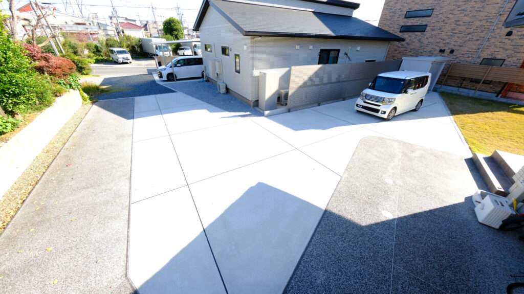 親子の建物をつなぐ動線の高低差を調整した刷毛引き仕上げの土間