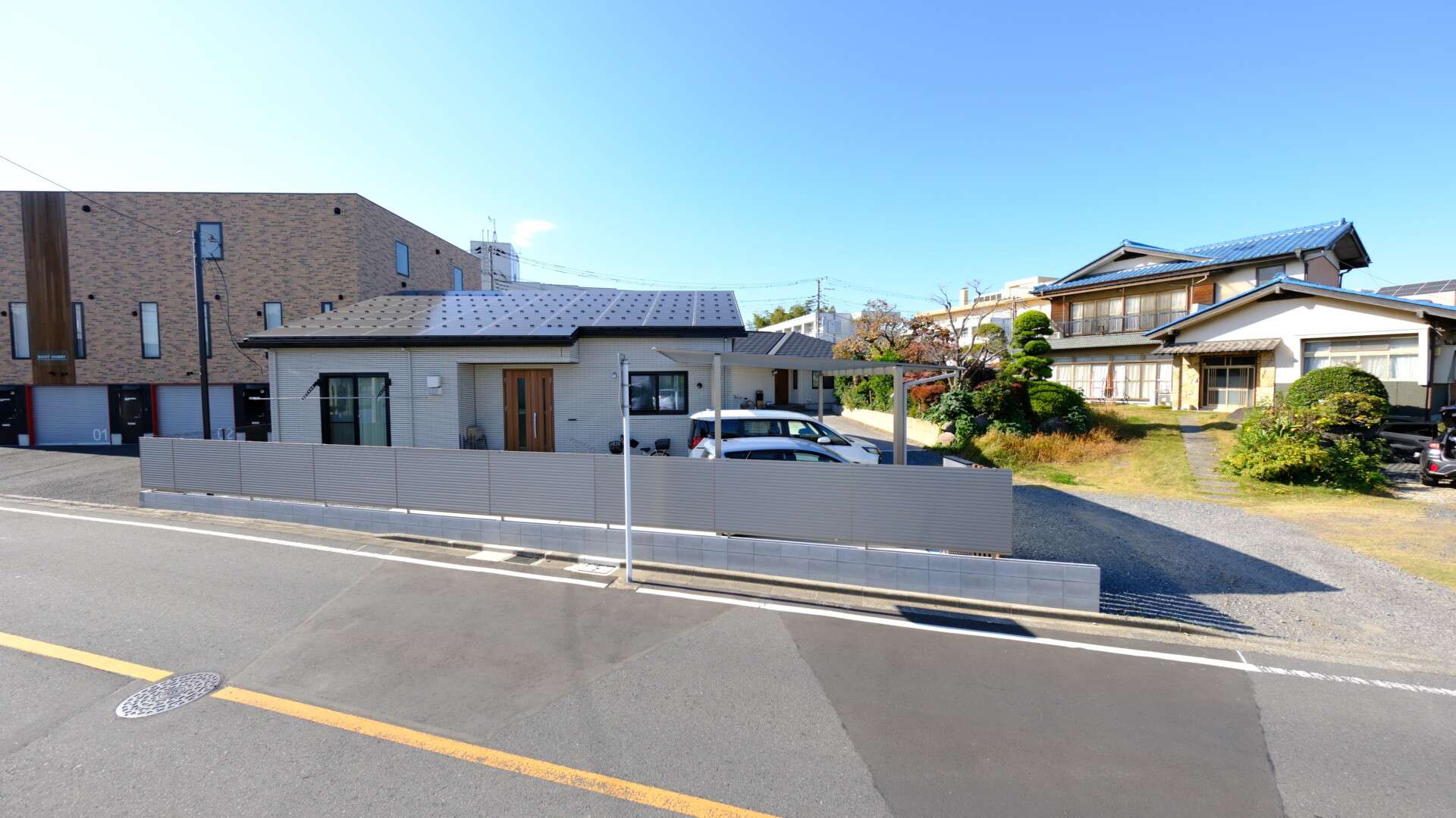 モダンなステンカラーのアルミ目隠しフェンスと広い庭の全景