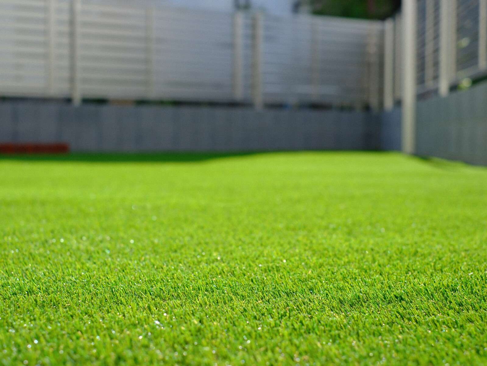 レンガ花壇と記念樹がある人工芝の庭。目隠しフェンスでプライバシーを確保した草加市の新築外構