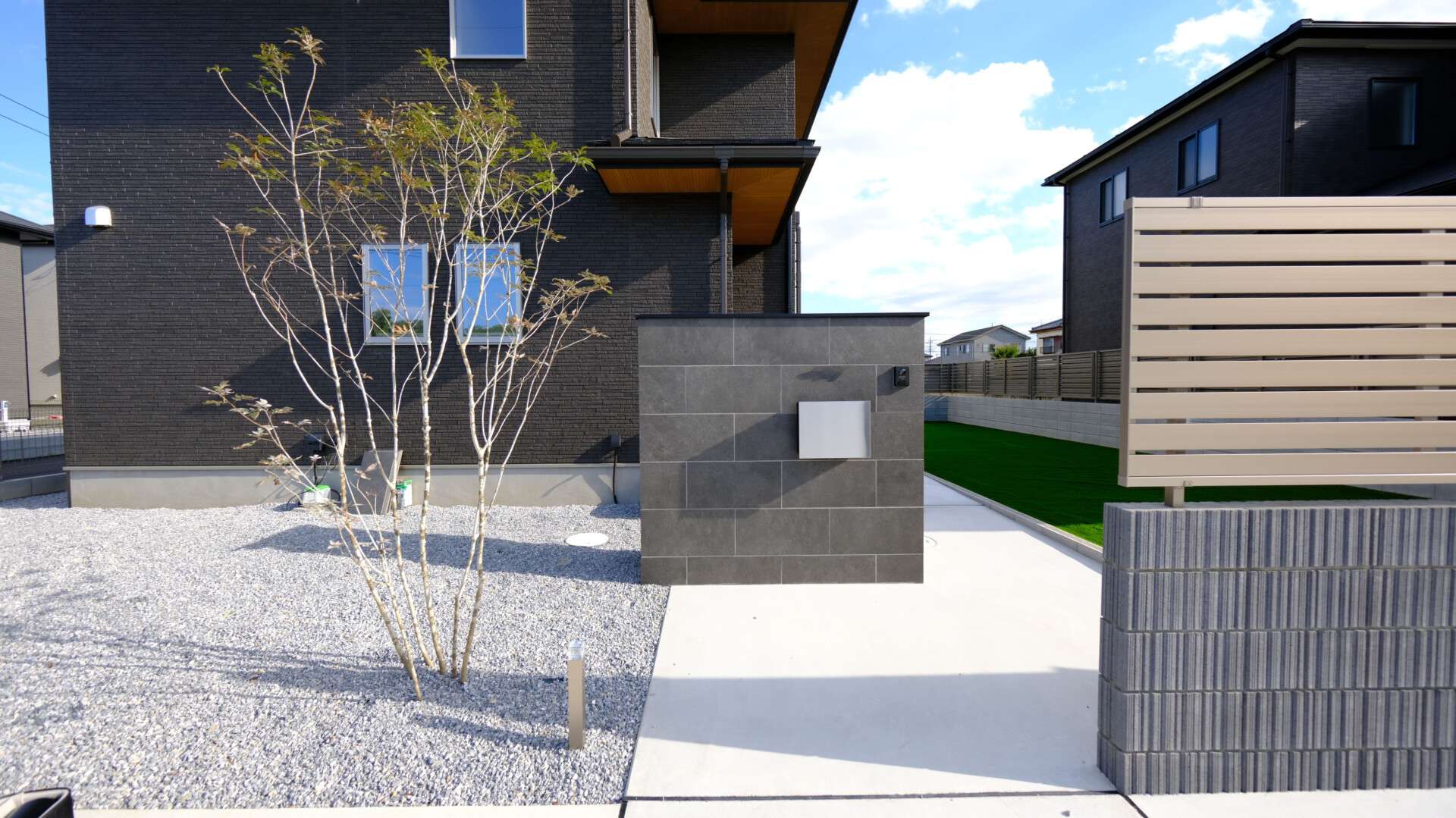 シンボルツリーのアオダモ。タイル門柱とのコントラストが上品な印象。