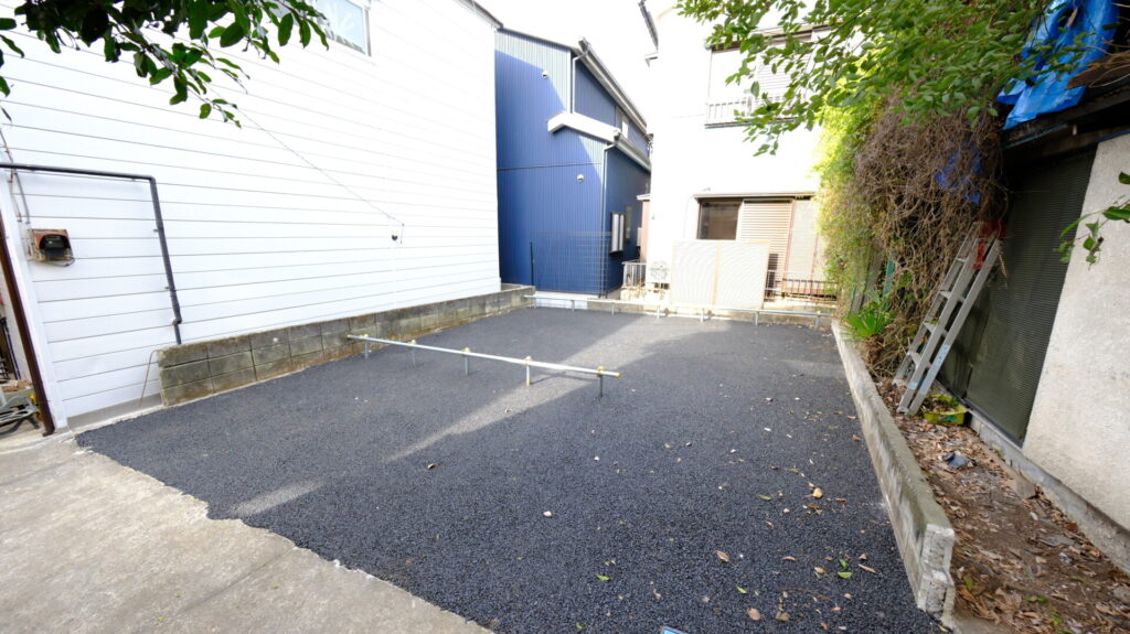 全面を黒いアスファルトで舗装し、単管パイプで区画を分けた清潔感のあるバイク置き場。