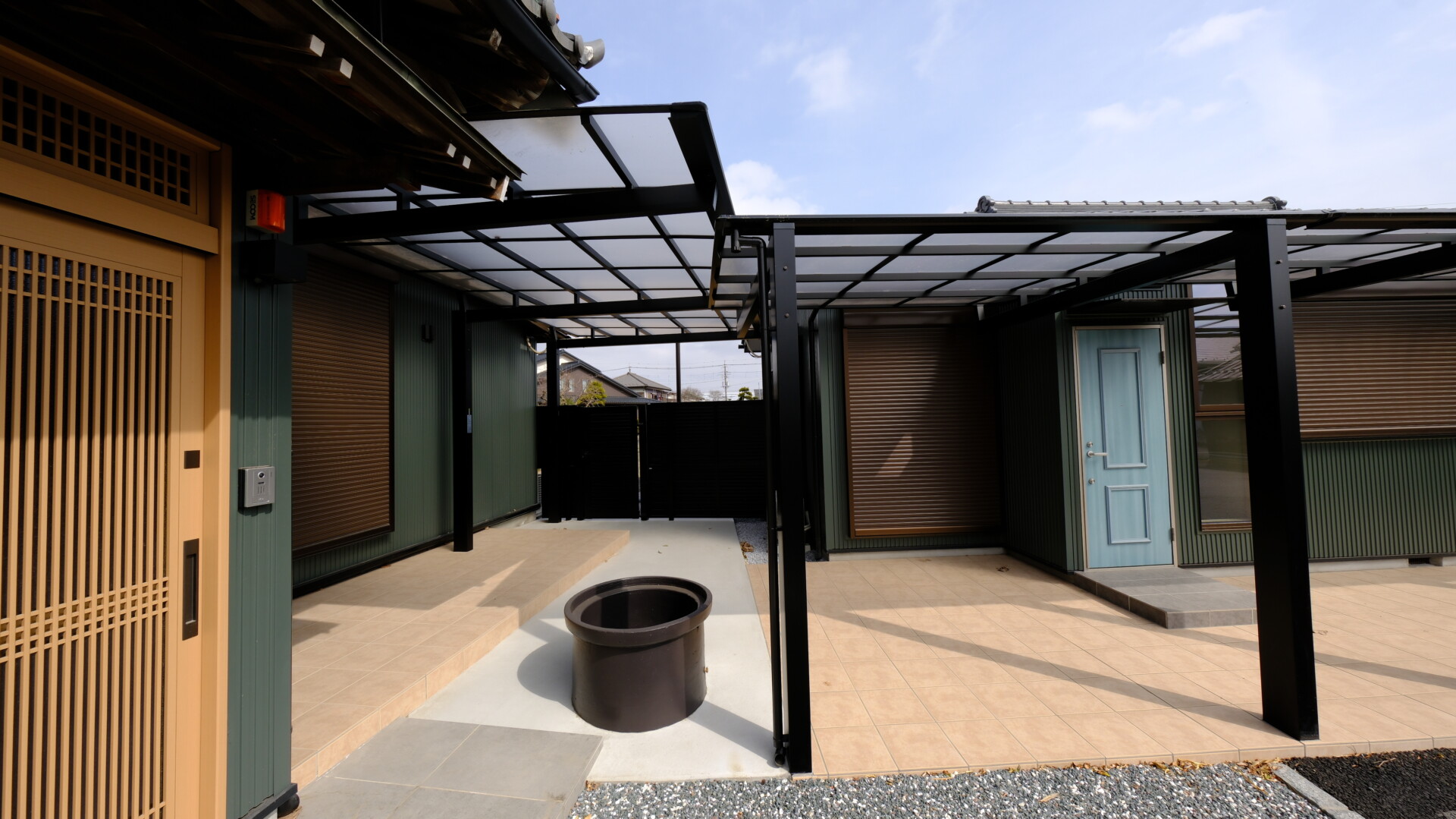 テラス屋根と風よけの間仕切りで機能性を高めた連絡通路