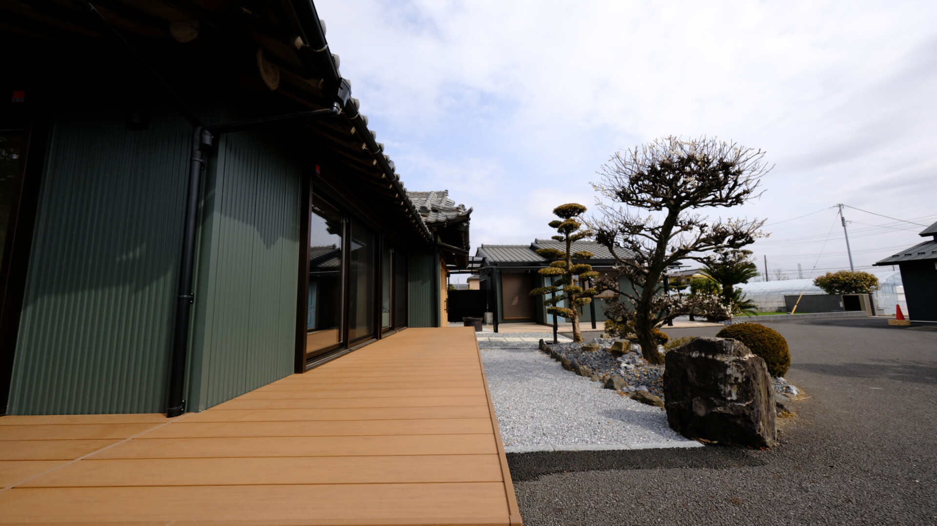 既存の植栽を活かし、足元に化粧砂利と石を配置したデッキからの景観