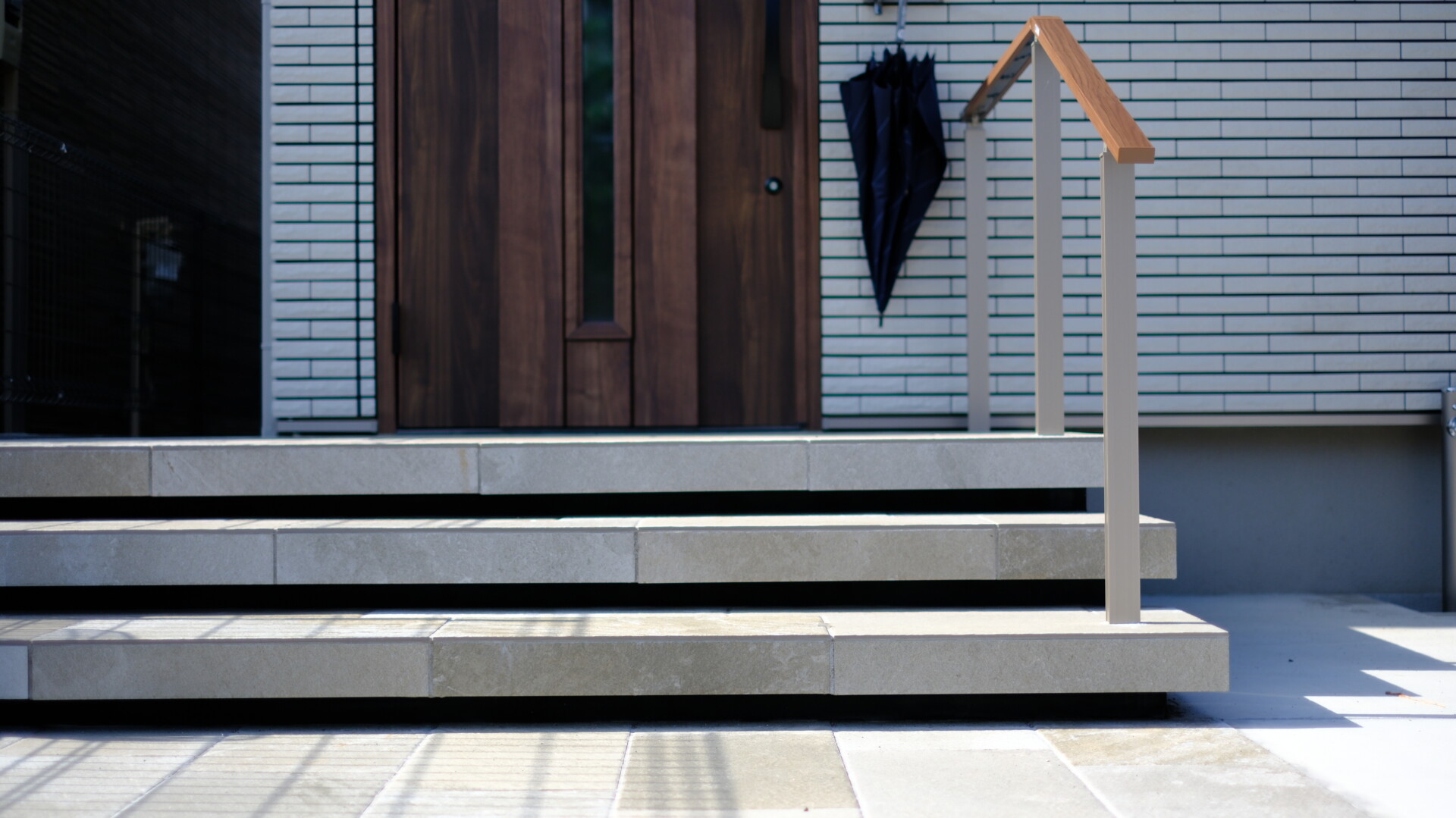 玄関ポーチから連続性を持たせた、浮き階段と黒い蹴込み部分のコントラスト