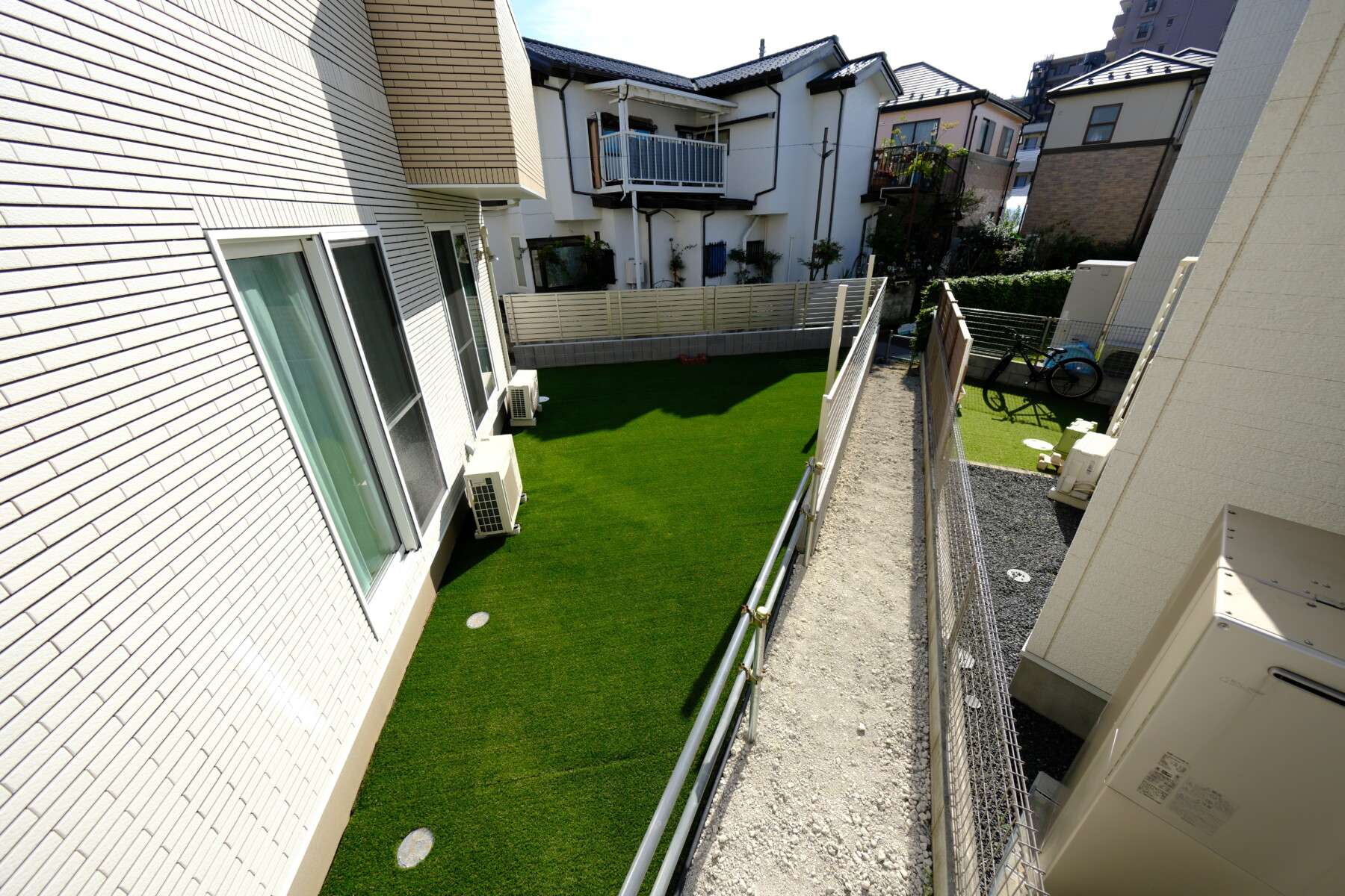 草加市・変形地を活かした一条工務店の新築外構全景。人工芝と目隠しフェンスで快適に整えられた庭とスペース