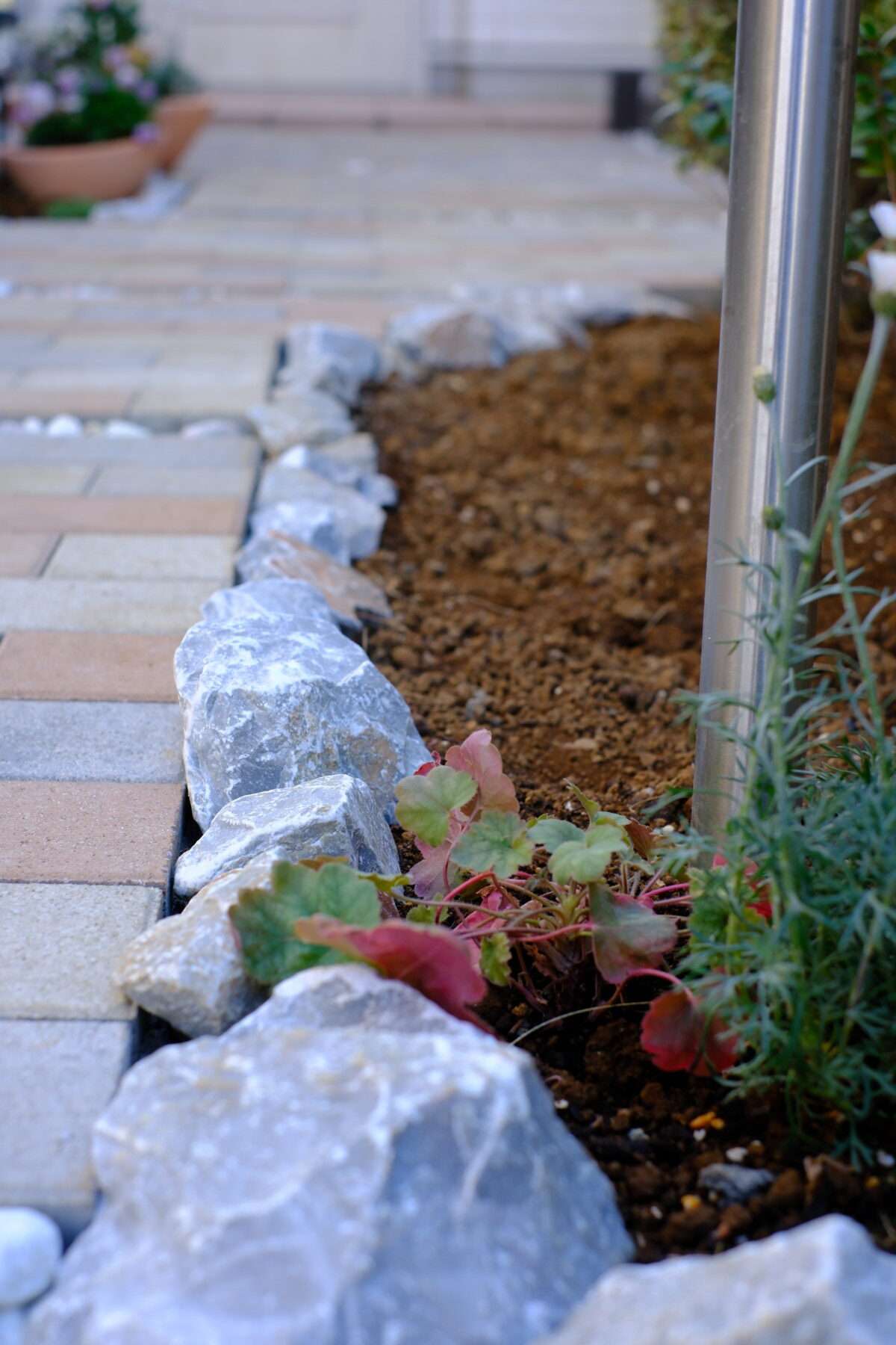 砂利とインターロッキングで整えたアプローチ脇の植栽スペース