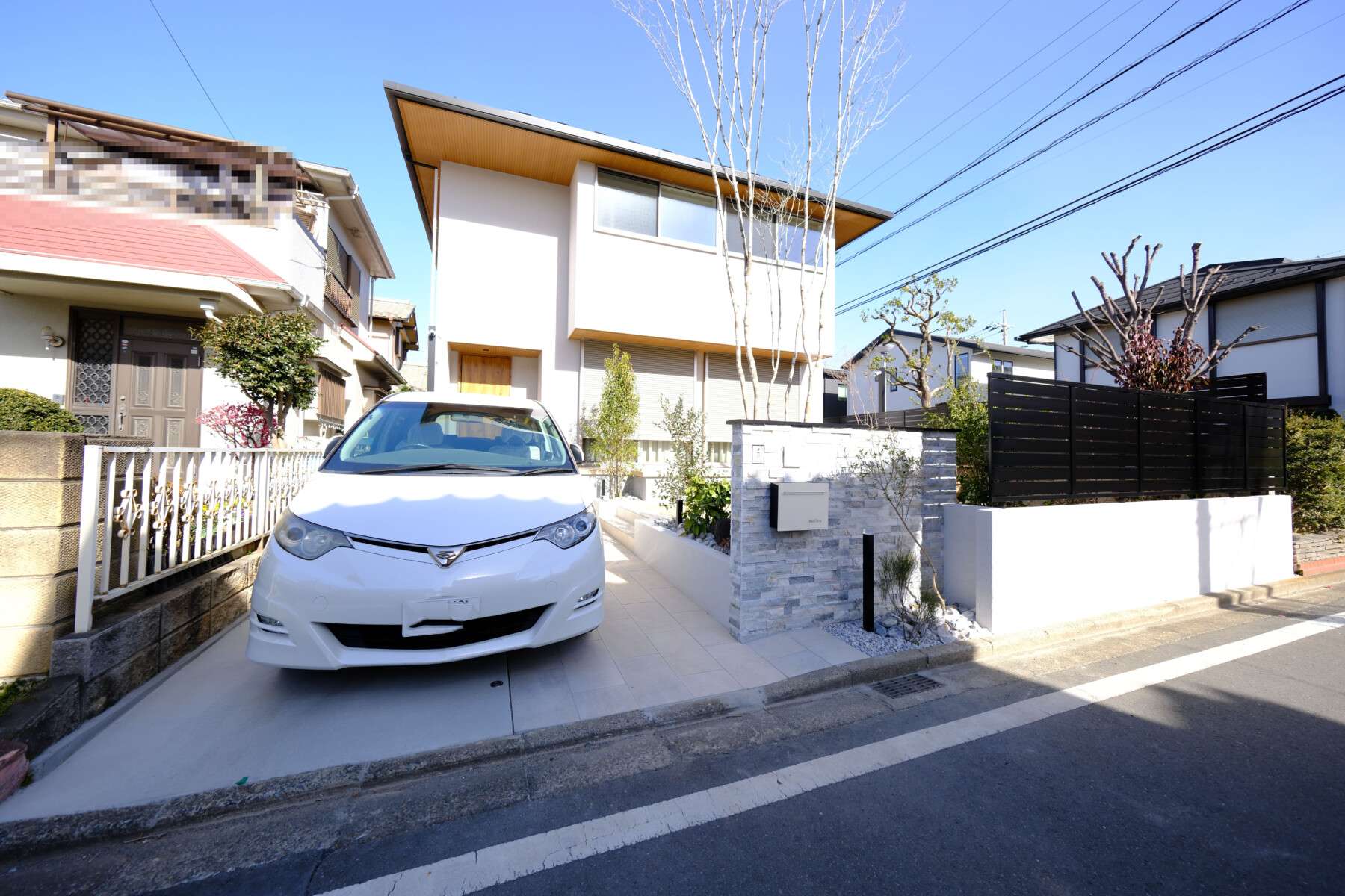 天然石タイルを使用した重厚感のある門柱と連続性を持たせた植栽とアプローチデザイン