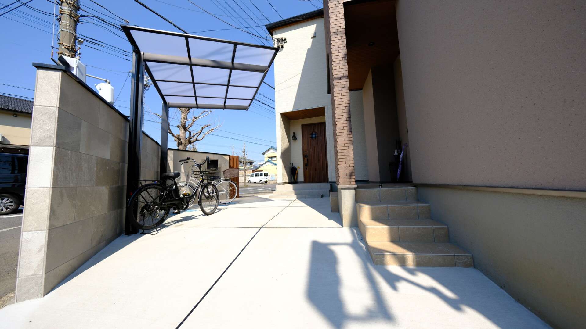 施工後の駐輪場兼軽自動車用スペース、塀と門柱で区切られた外構