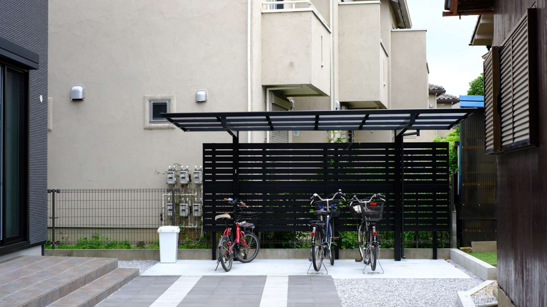駐輪場背面の目隠しフェンスでプライバシーを確保した外構