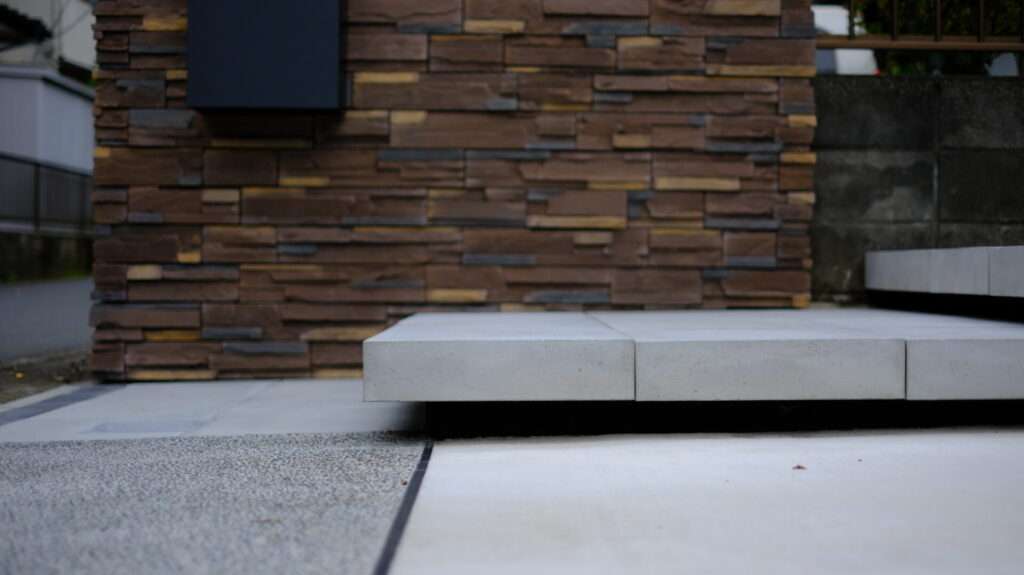 東洋工業ニュートステップを使用した浮き階段アプローチ。広めのステップとブラックのジョリパッド仕上げ。