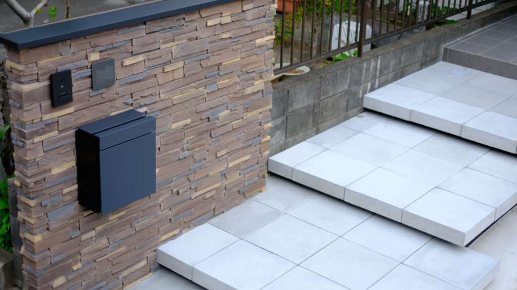 門柱とアプローチ階段の取り合い部分。素材と色のコントラストが特徴的。