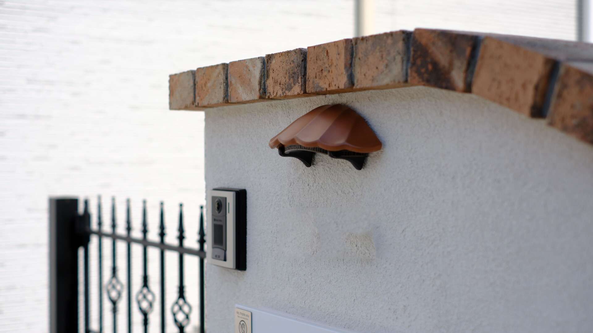 ディーズガーデン製照明と斜めに角度をつけたレンガ笠置を設置した門袖