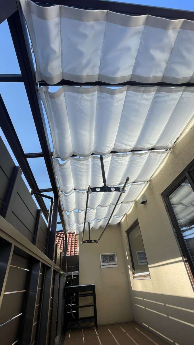 ベランダに設置されたテラス屋根「ナチュレ」と、夏場の日差しをカットする可動式日よけ。