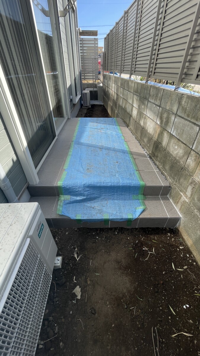 境界ブロックに寄せて設置し、スペースを有効活用したリビング前のタイルデッキ