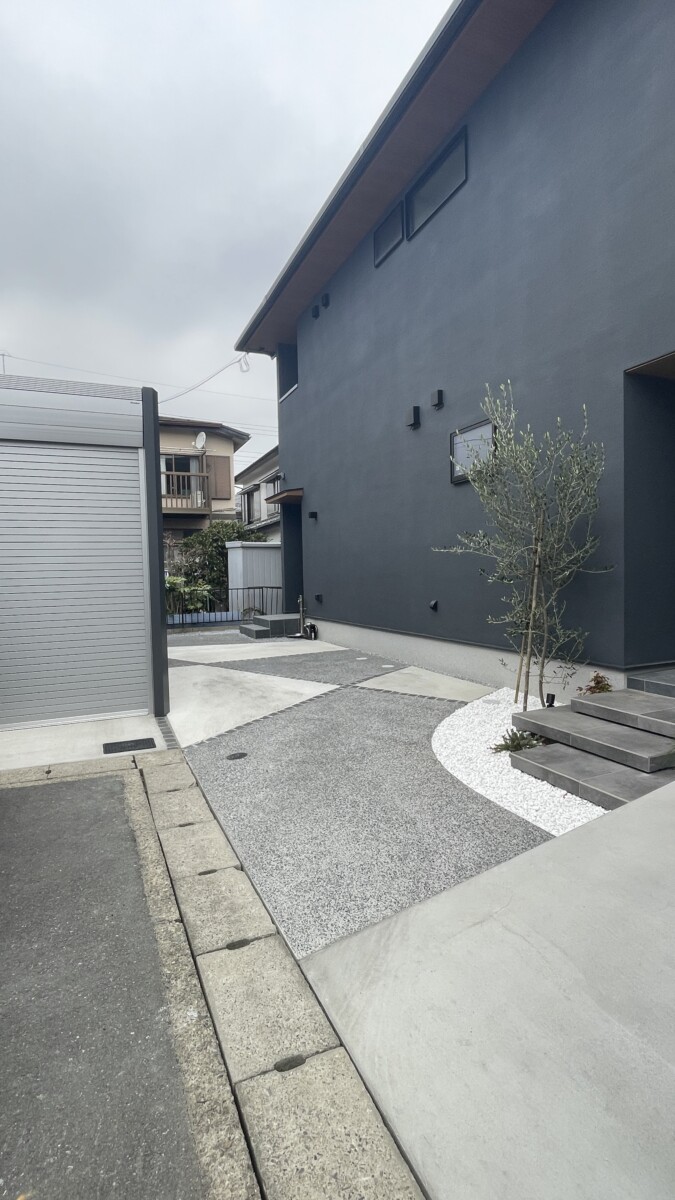 和モダンな建物と調和する洗い出しと土間コンクリートのパターンと、イナバガレージ「アルシア」