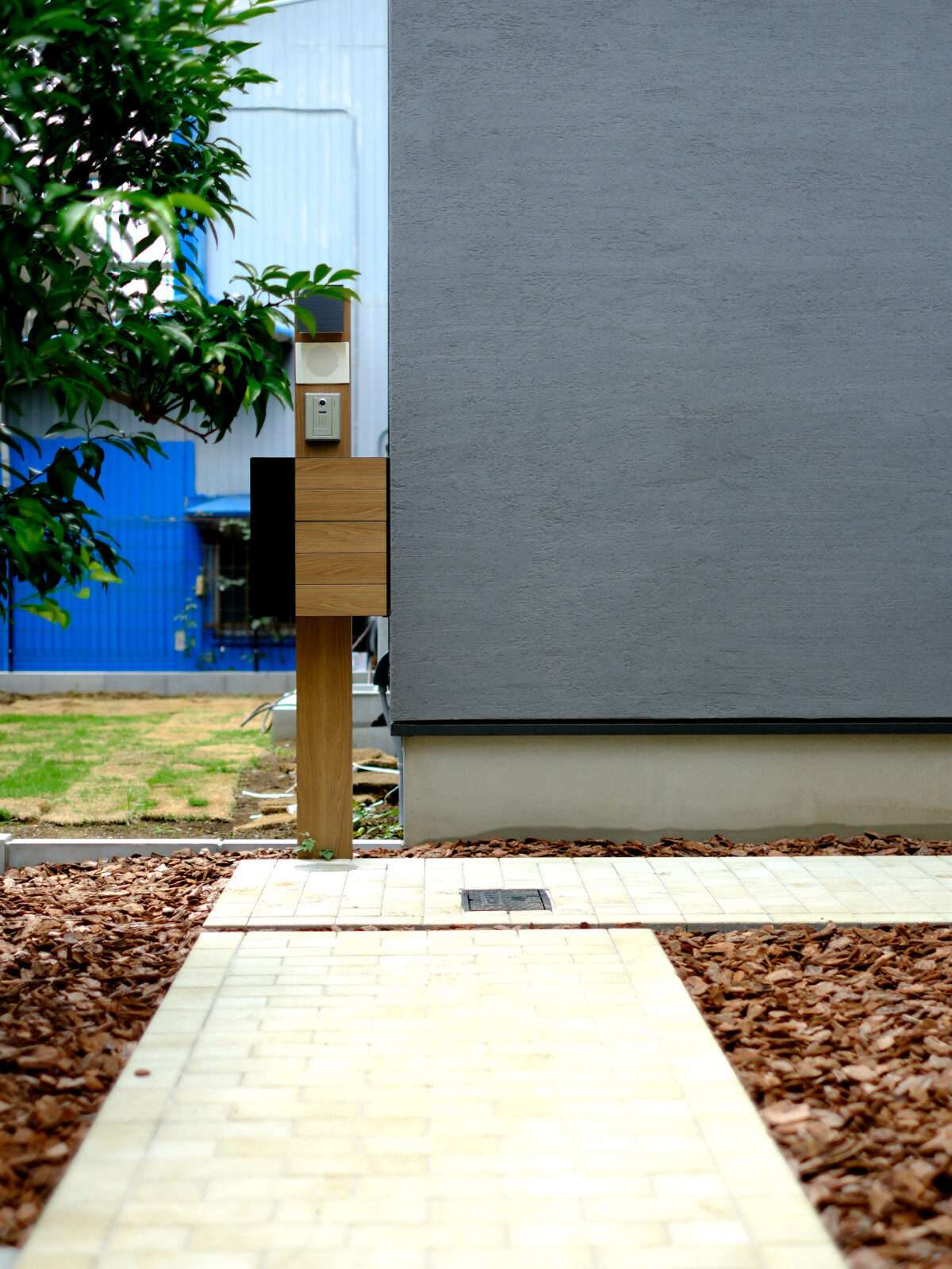 アプローチ途中に設置された木目調の機能門柱FW