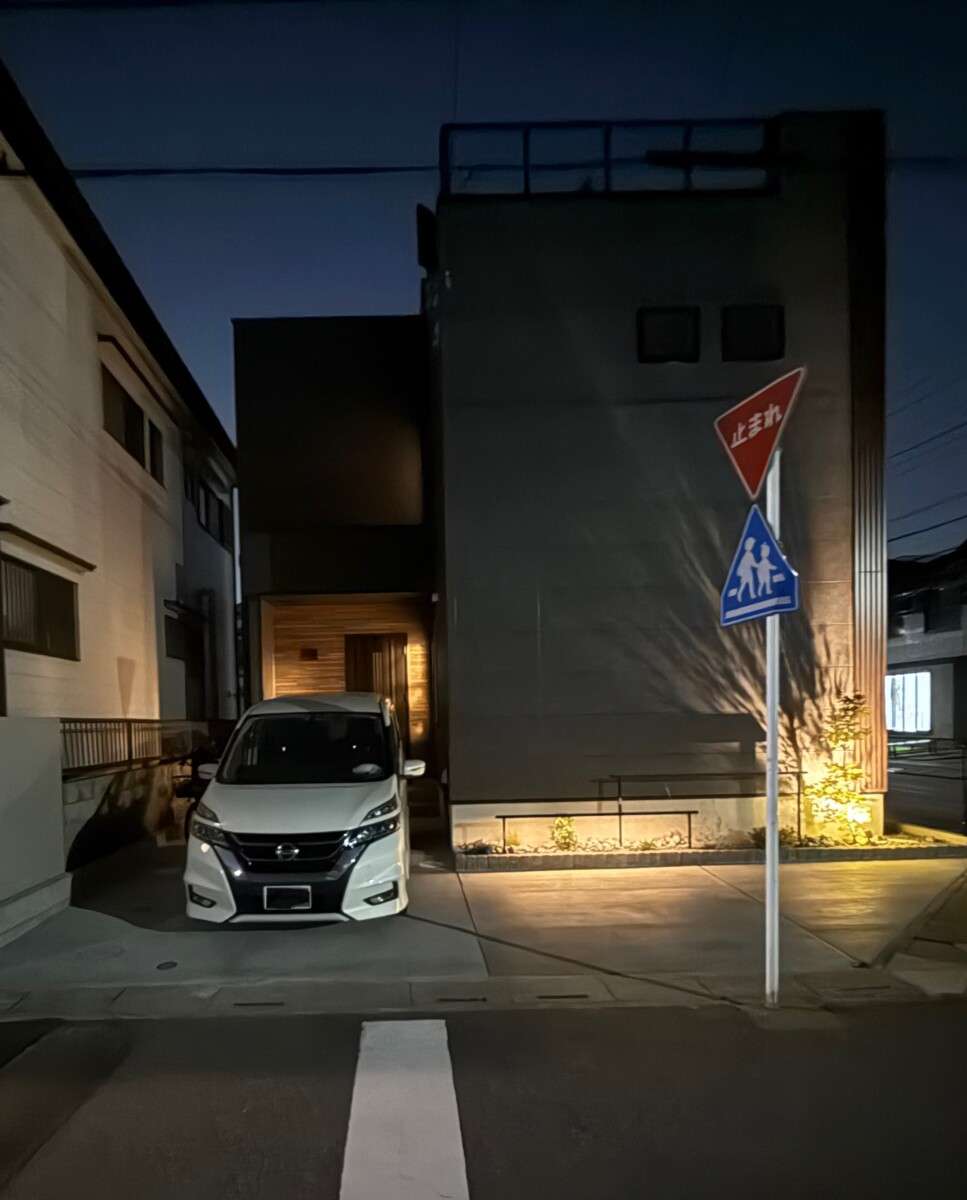 夜間照明で植栽と石が浮かび上がる越谷市の外構演出