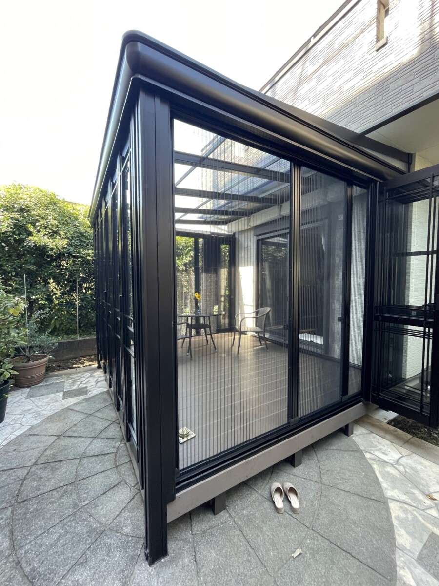 室内と外部が調和したガーデンルームの一部。窓から心地よい風が流れ込み、リラックスできる雰囲気が伝わるシーンです。