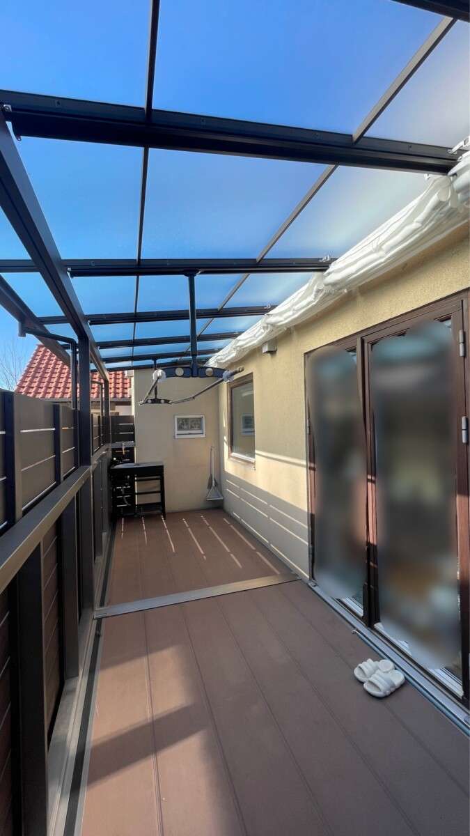 奥行きを活かし、人工木デッキで仕上げた「三協アルミ オルネ」の広々とした床面。