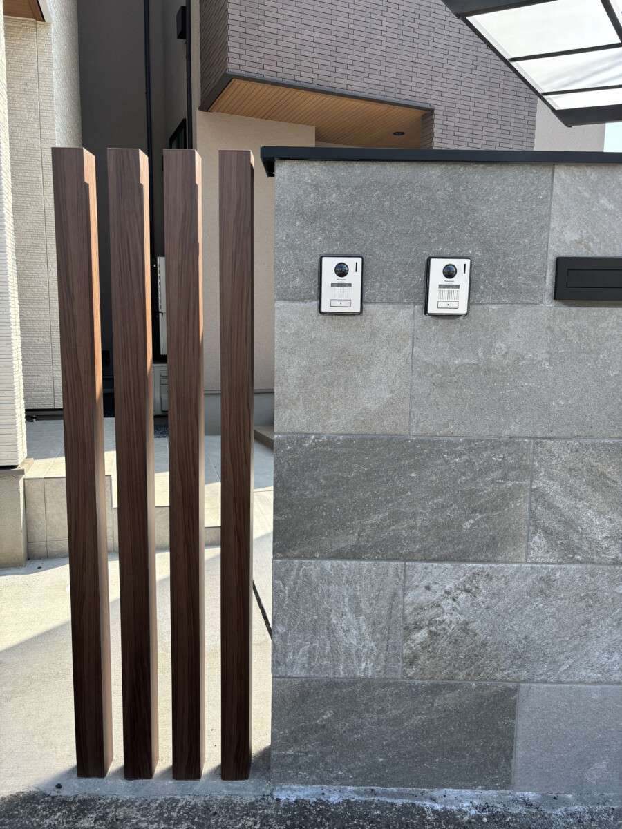 大判タイル門柱とポスト・表札が一体化した塀とアクセントの木調アルミ柱