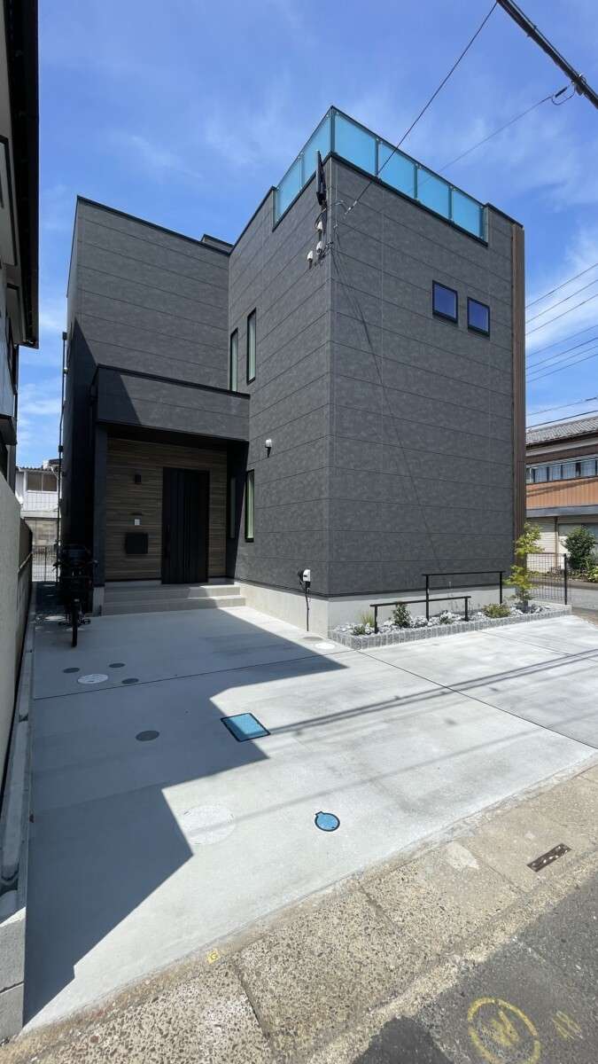 ロックガーデン風花壇とコンクリートアプローチが調和した越谷市の新築外構