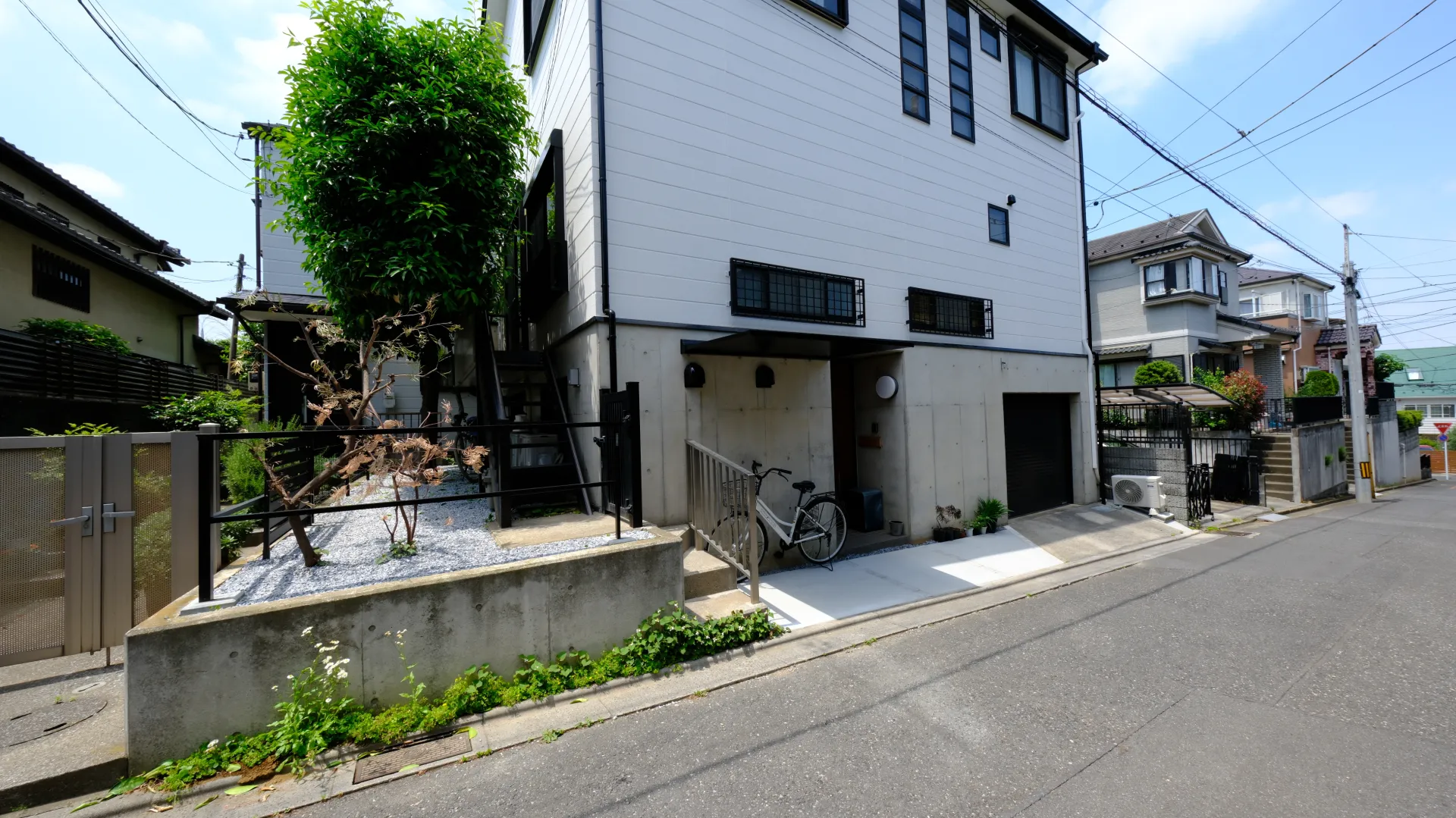 生け垣を撤去してLIXILフェンスALとシンプルな植栽に一新。建物の輪郭が整い、モダンな外観に生まれ変わった施工後の様子。