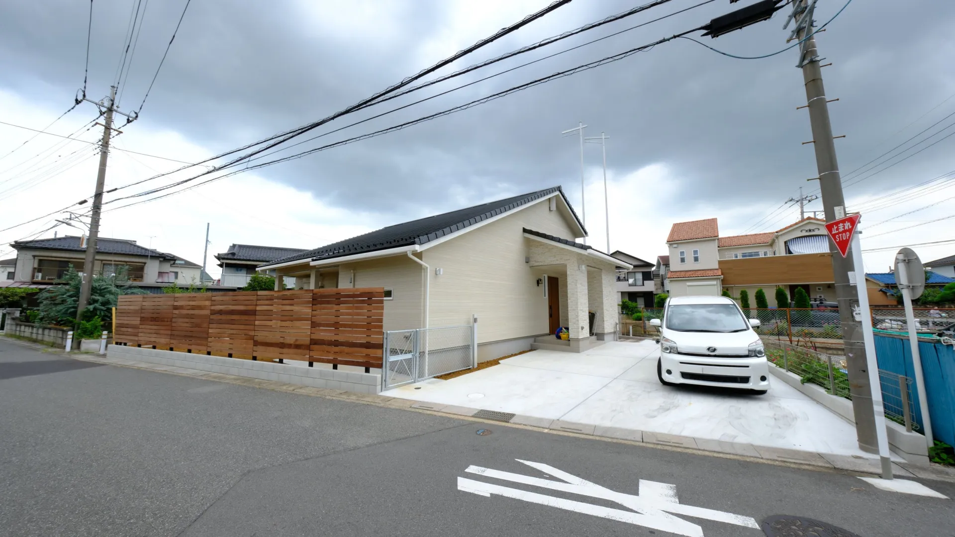 西海岸風にまとめた新築平屋の外構全体、天然木フェンスと土間コンクリートの駐車スペース（越谷市）