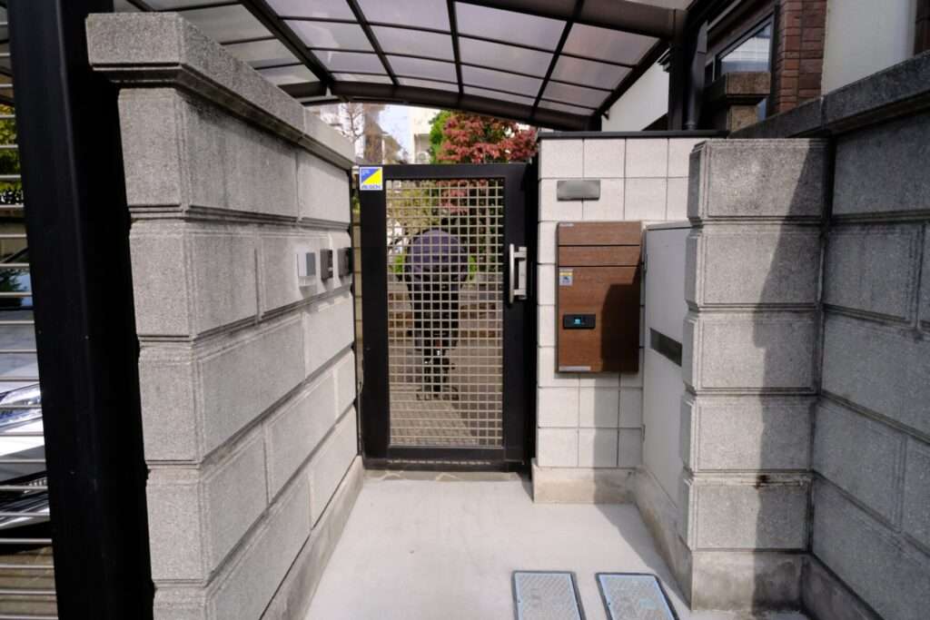 施工後の門まわり。木目調の宅配ボックスとスクエアブロックのデザイン