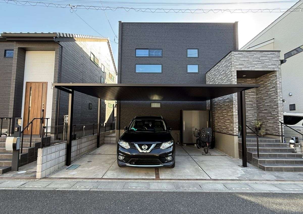 FⅡカーポートを正面から見た昼間の外構全景。黒いフレームが住宅と調和したスタイリッシュな印象