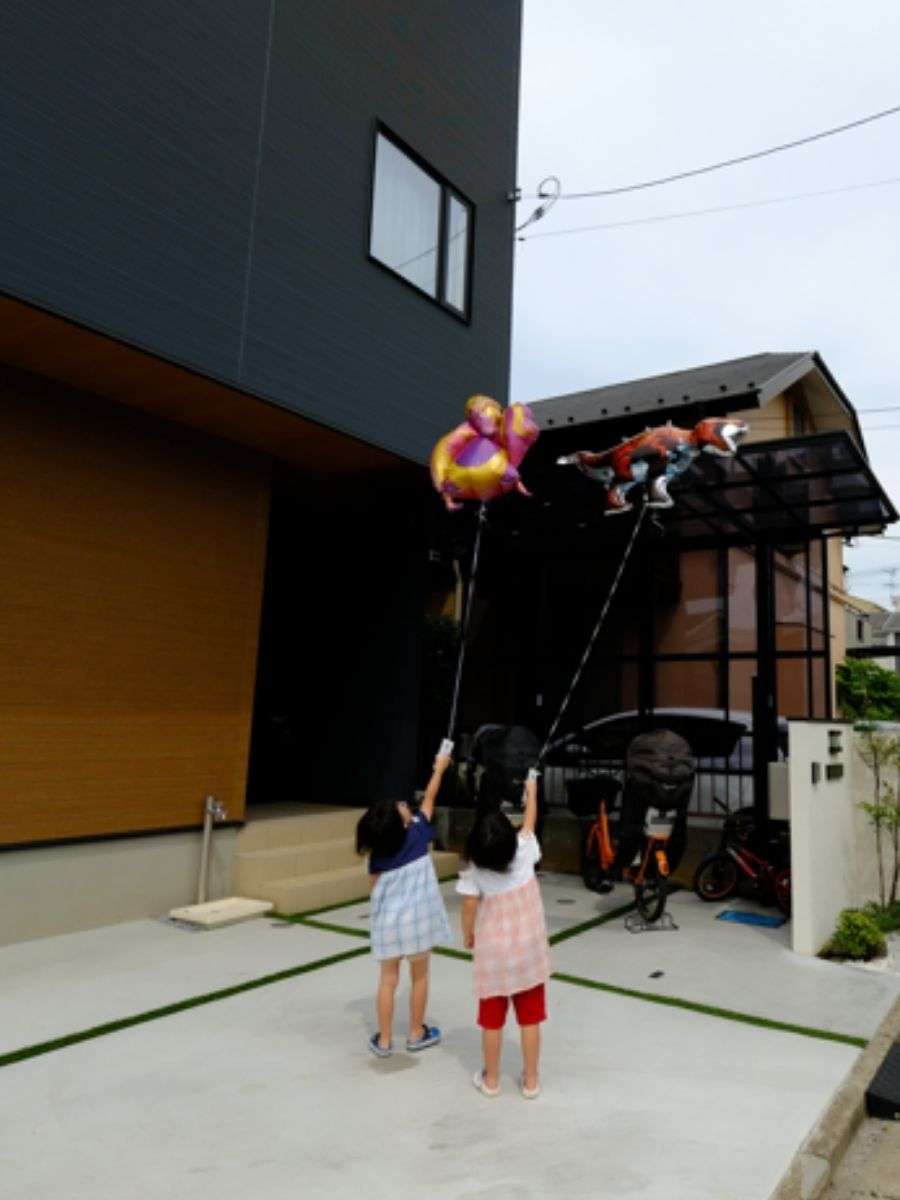 土間コンクリートの上で風船を上げて楽しむ子供たち